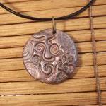 Polymer clay pendant in a c..