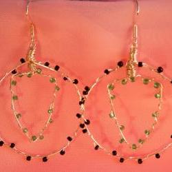 Wire hooped earrings with seed beads. hooped outer and shield shaped inner, opaque black and matt green seed beads. handmade.